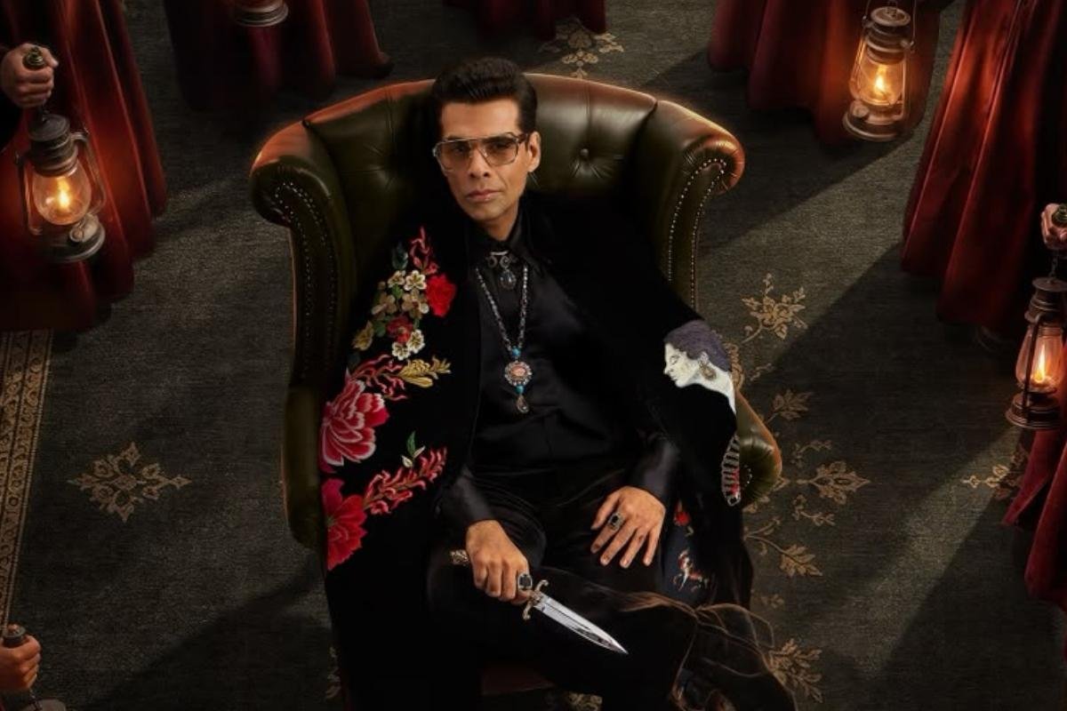 Karan Johar seated on an elegant chair holding a dagger in the official announcement poster of The Traitors Season 2 with dramatic lantern lighting.